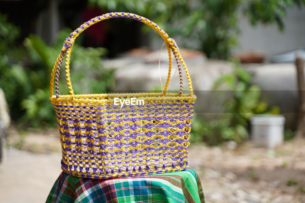 CLOSE-UP OF MULTI COLORED PLANT IN BASKET WITH WICKER