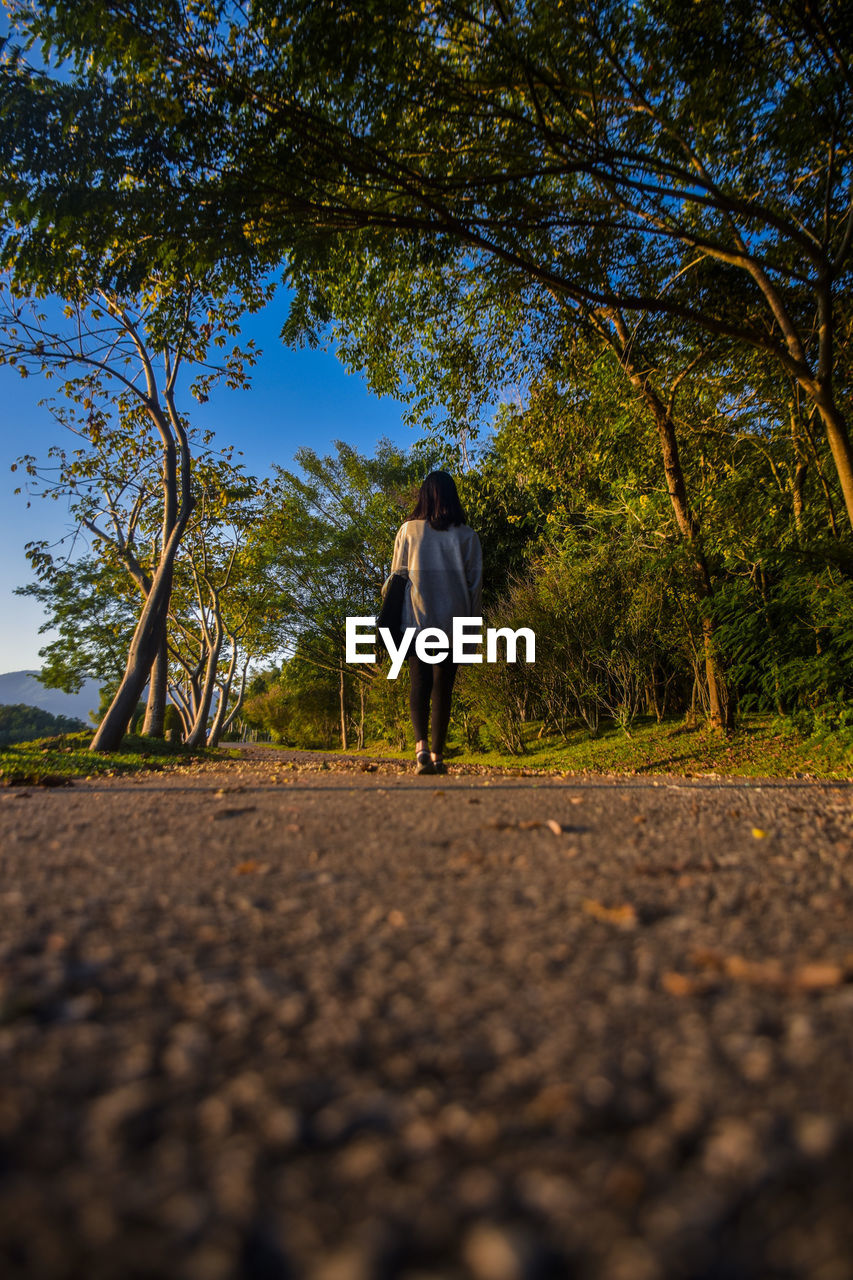 FULL LENGTH REAR VIEW OF WOMAN WALKING ON STREET