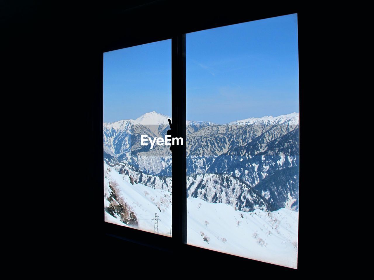 SNOWCAPPED MOUNTAINS SEEN THROUGH WINDOW