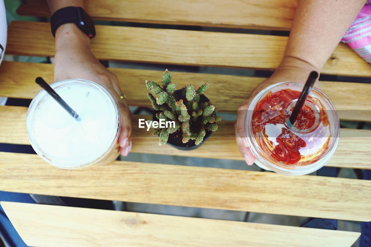 High angle view of hand holding drink on table