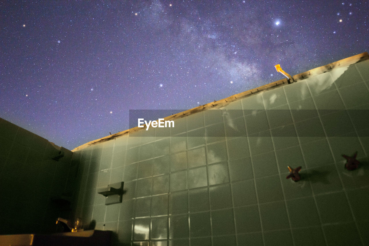 LOW ANGLE VIEW OF BUILDINGS AGAINST SKY AT NIGHT