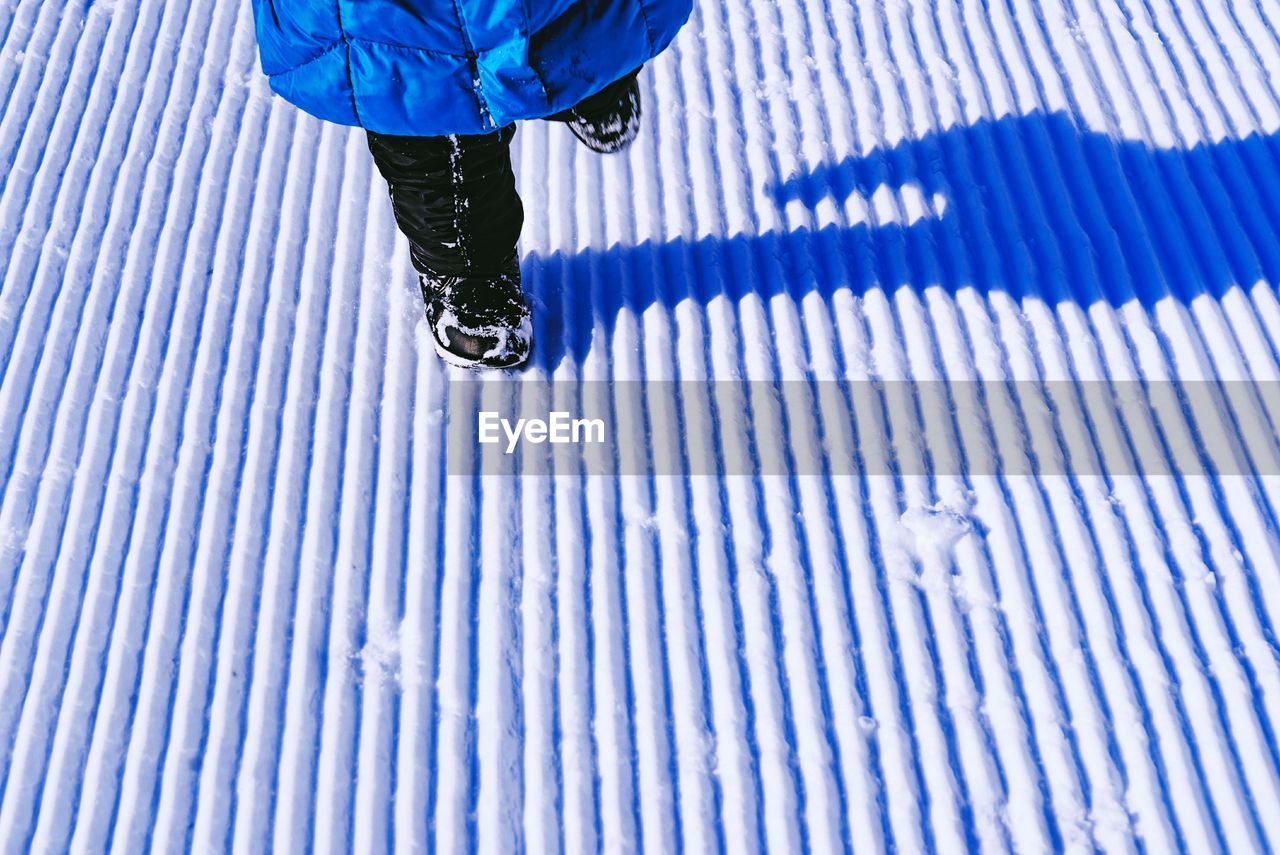 Low section of child walking on snow