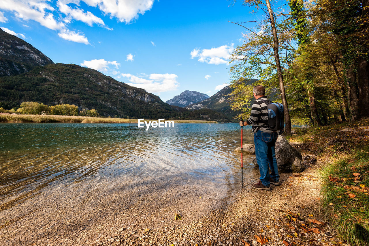 Full length of man standing by lake against sky