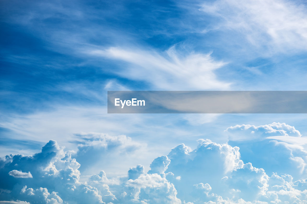 Low angle view of sunlight streaming through clouds