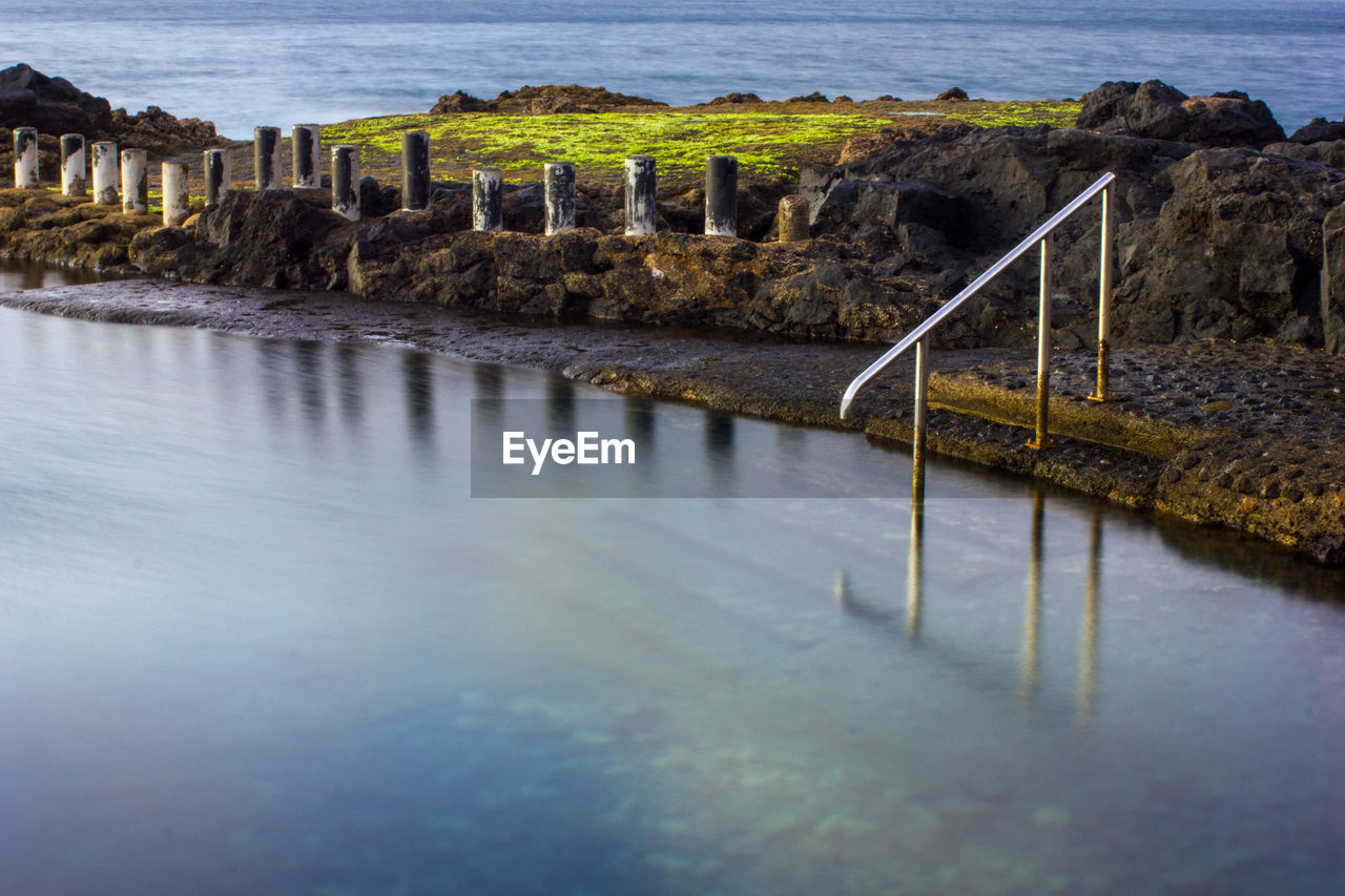 water, reflection, shore, coast, sea, ocean, nature, land, architecture, bay, no people, wave, sky, beach, scenics - nature, rock, built structure, beauty in nature, tranquility, travel destinations, outdoors, body of water, tranquil scene, day, environment, travel, morning