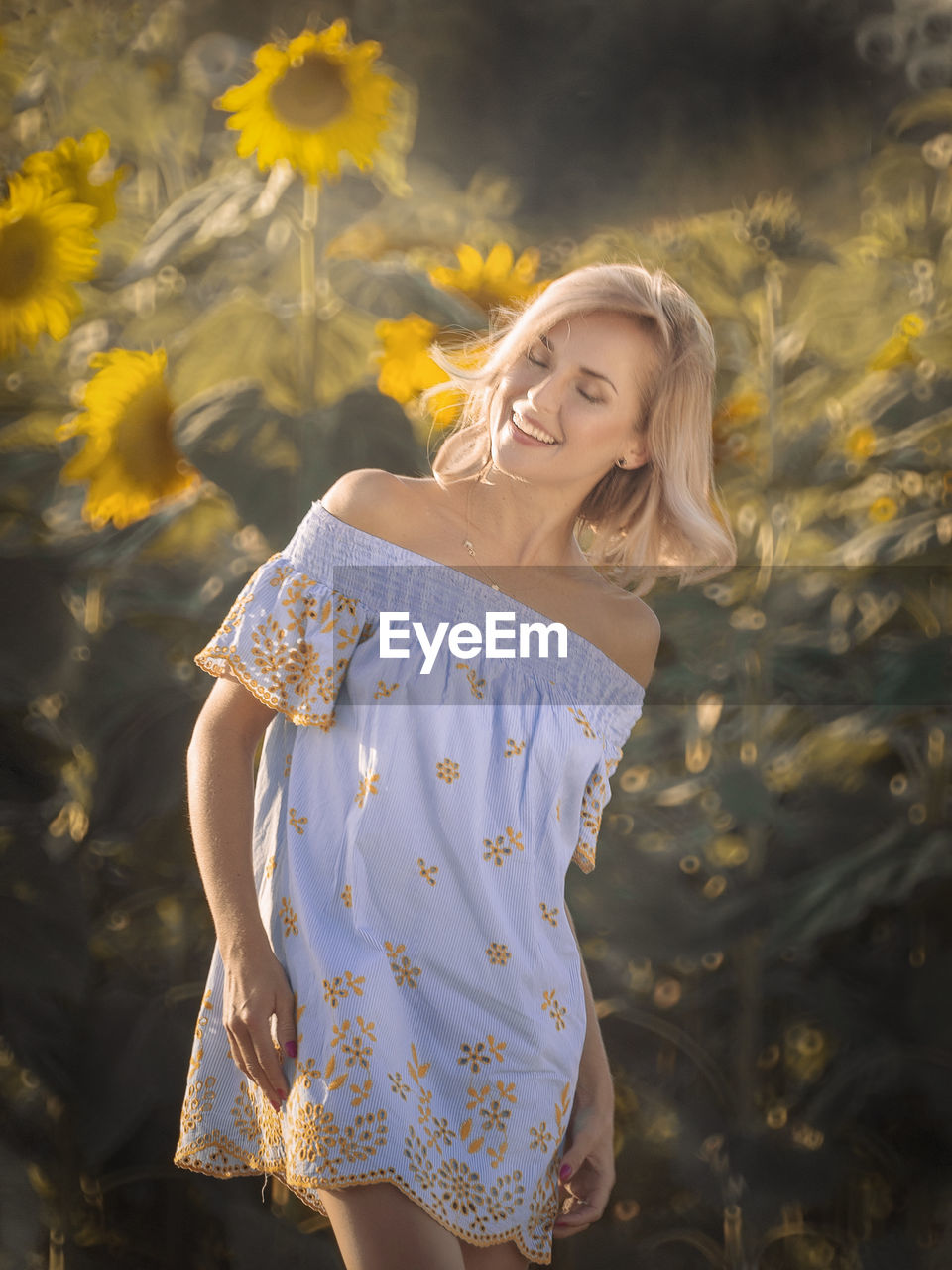 Beautiful woman standing at sunflower farm