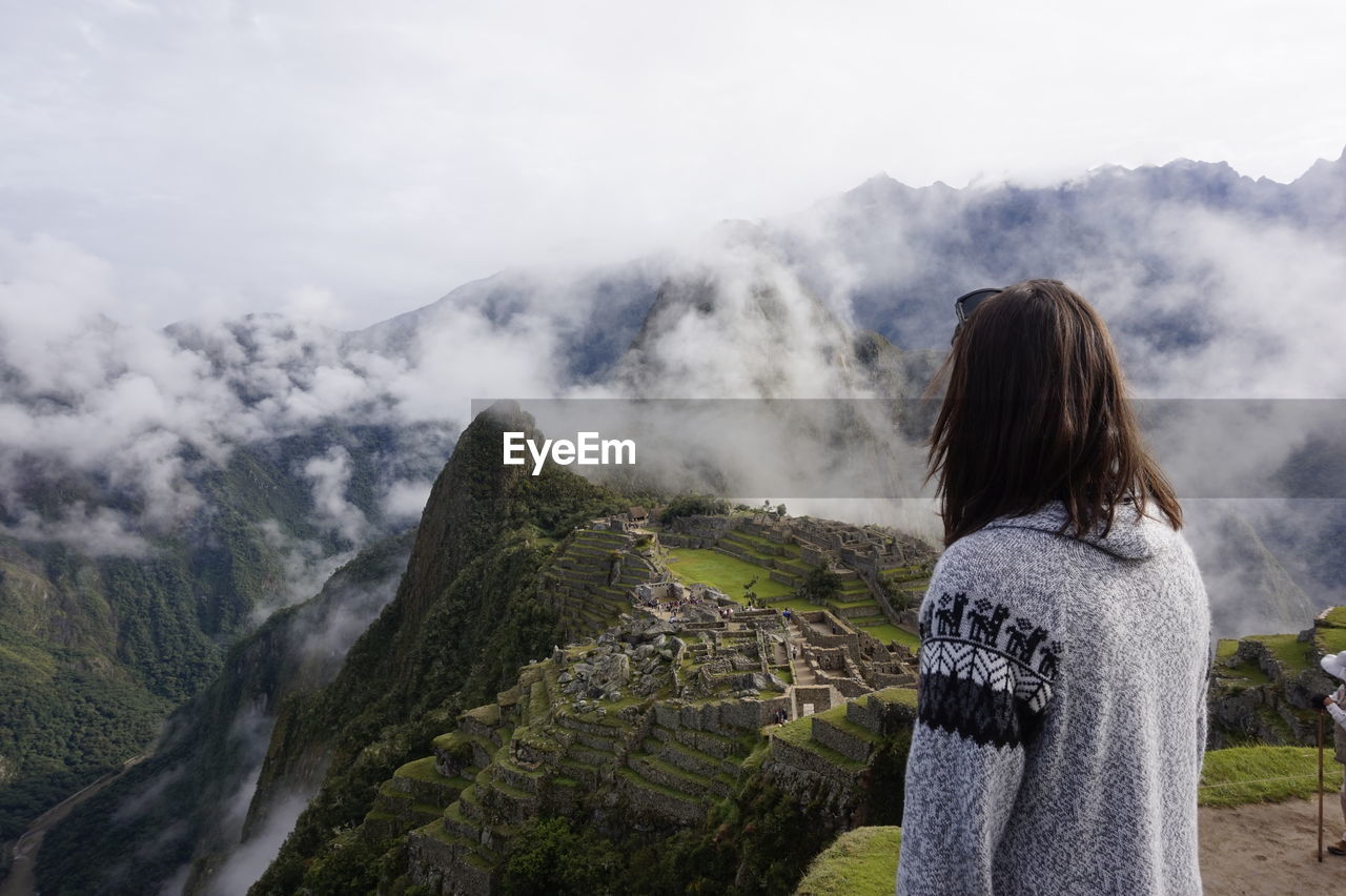 Woman looking at mountains against sky