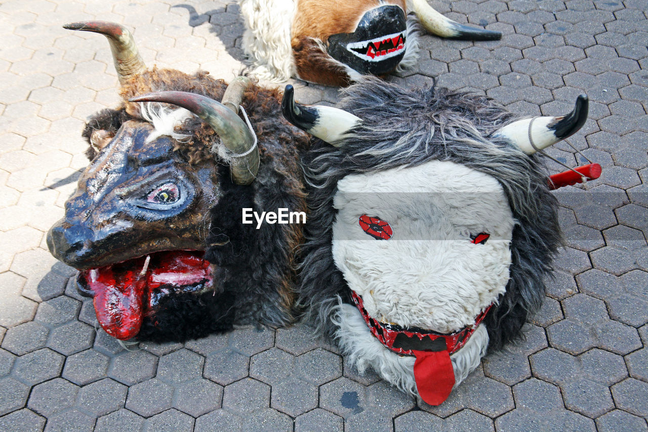 High angle view of demon masks on footpath