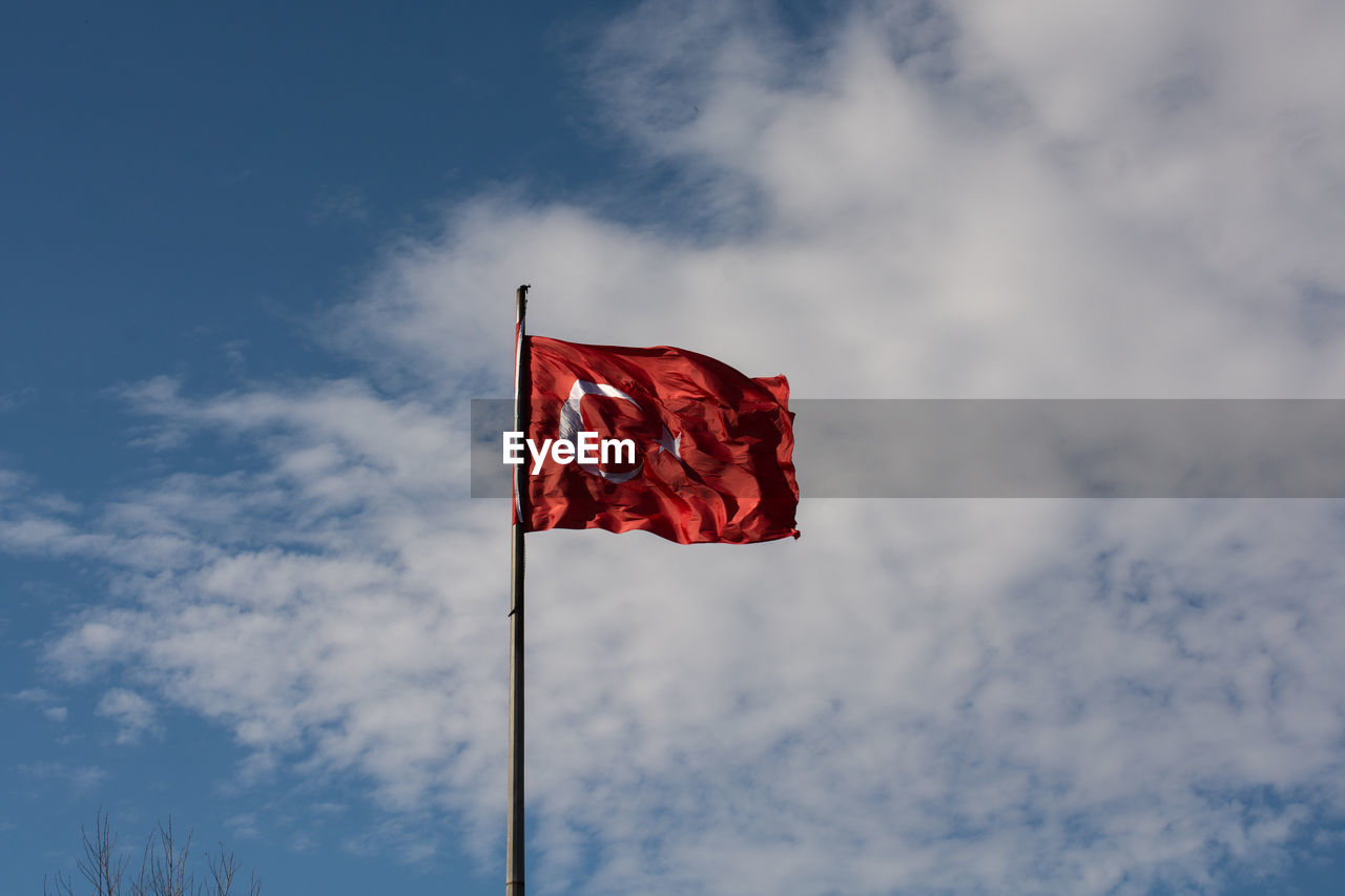 LOW ANGLE VIEW OF RED FLAG AGAINST SKY