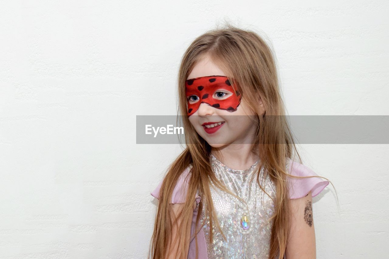 PORTRAIT OF A SMILING GIRL OVER WHITE BACKGROUND