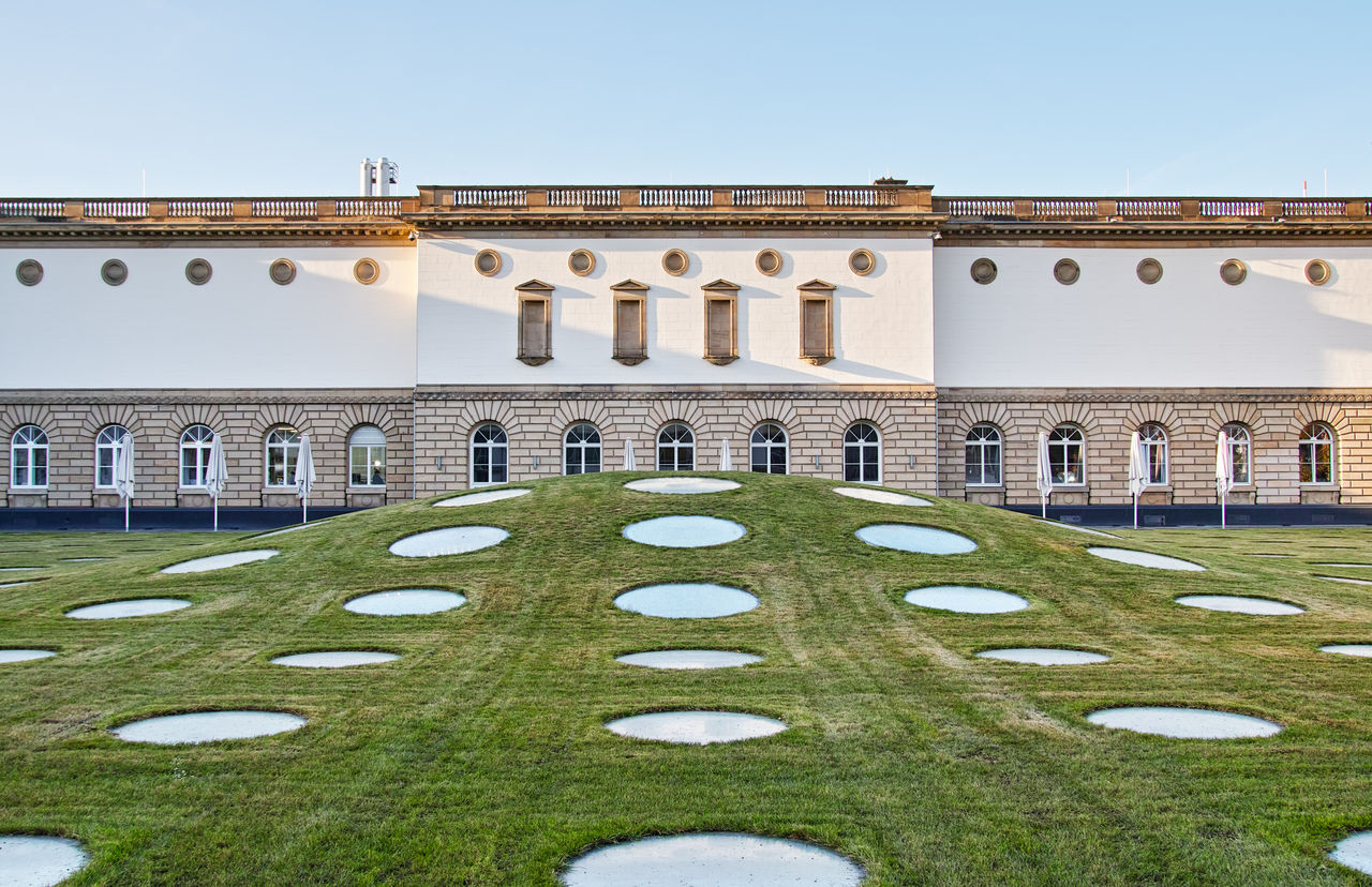 Historical building and garden against clear sky