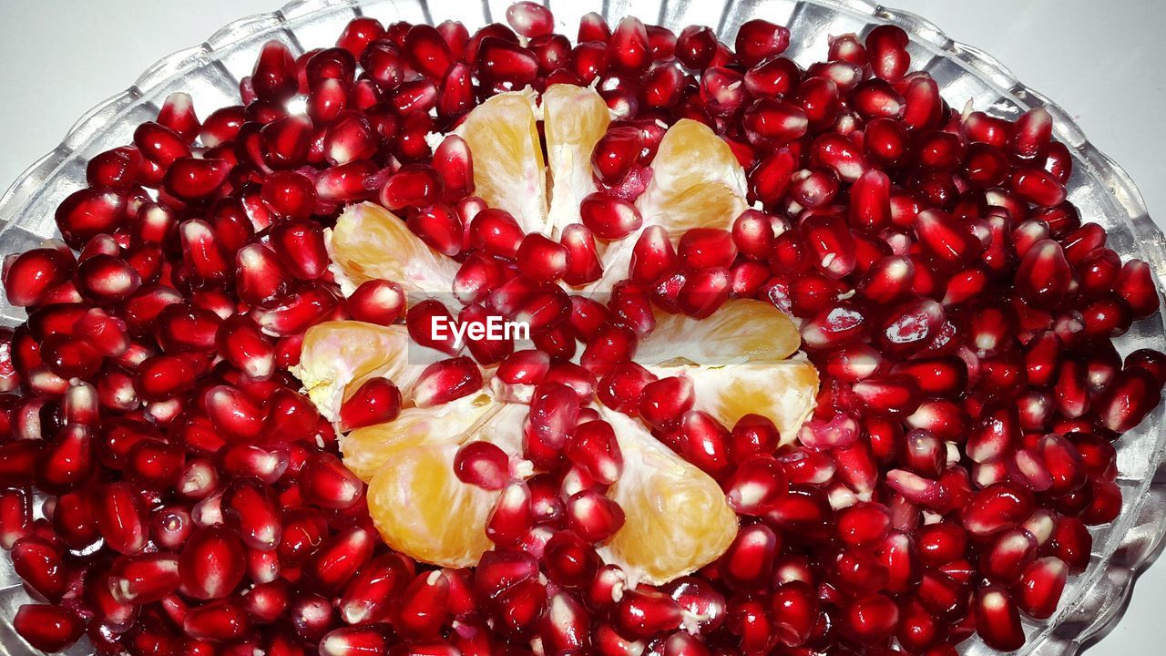 High angle view of orange slice and pomegranate seeds in bowl