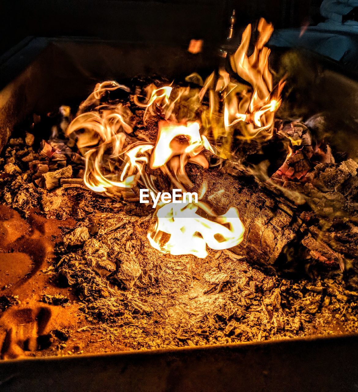 CLOSE-UP HIGH ANGLE VIEW OF BONFIRE AT NIGHT