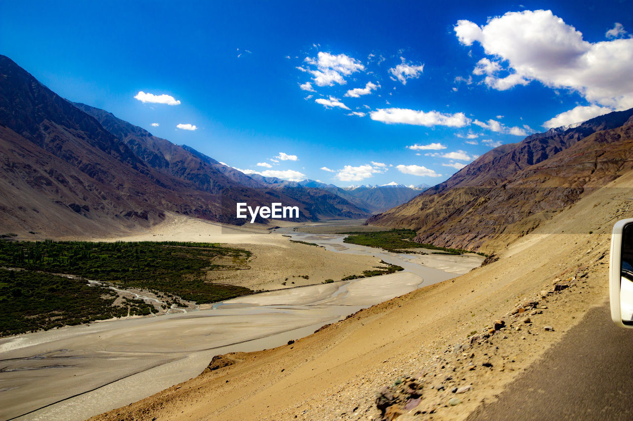 SCENIC VIEW OF ROAD AMIDST MOUNTAINS AGAINST SKY