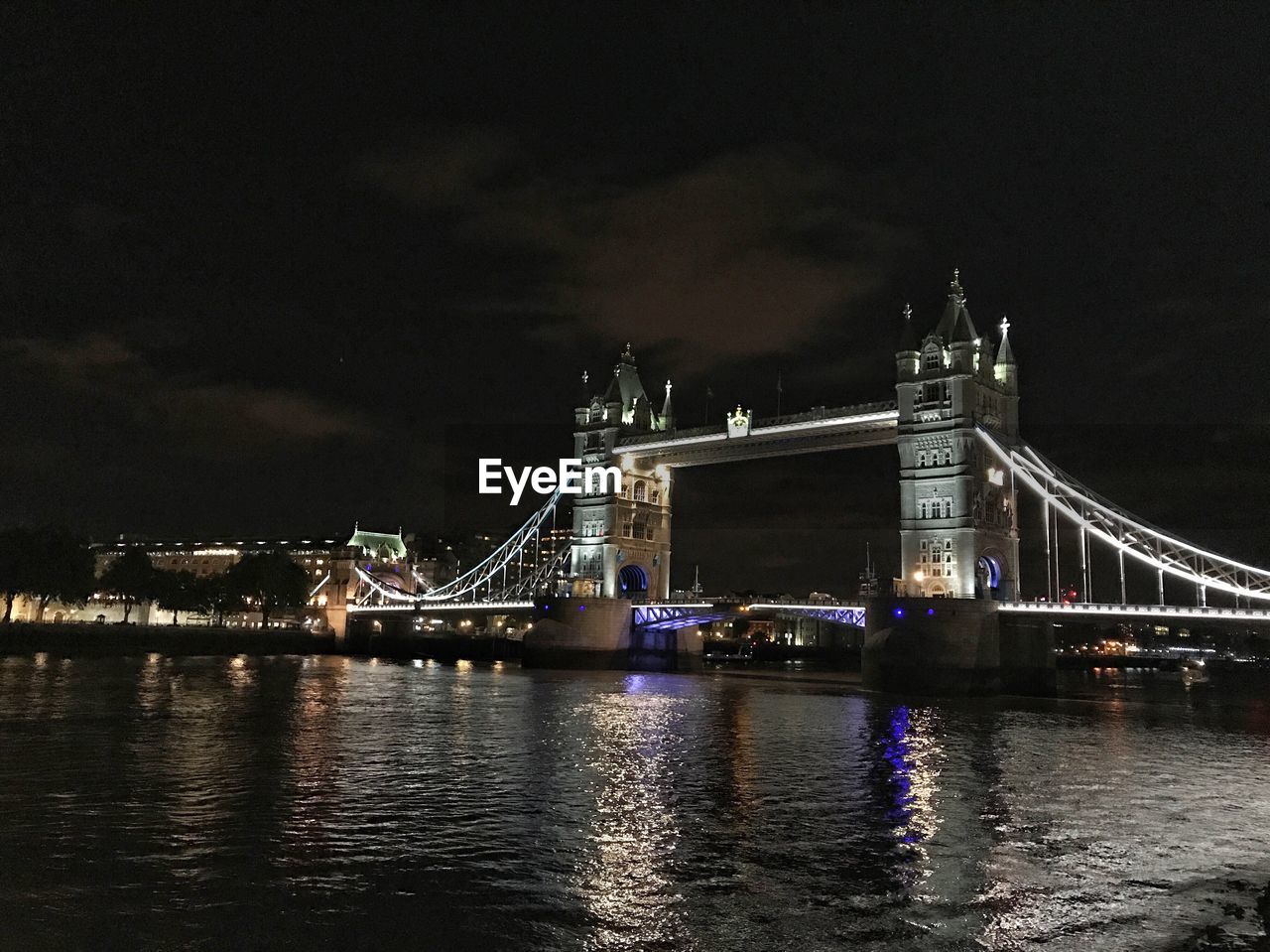 Illuminated tower bridge over thames river in city at night