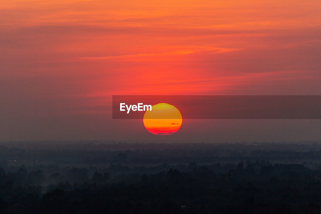 Scenic view of silhouette landscape against orange sky