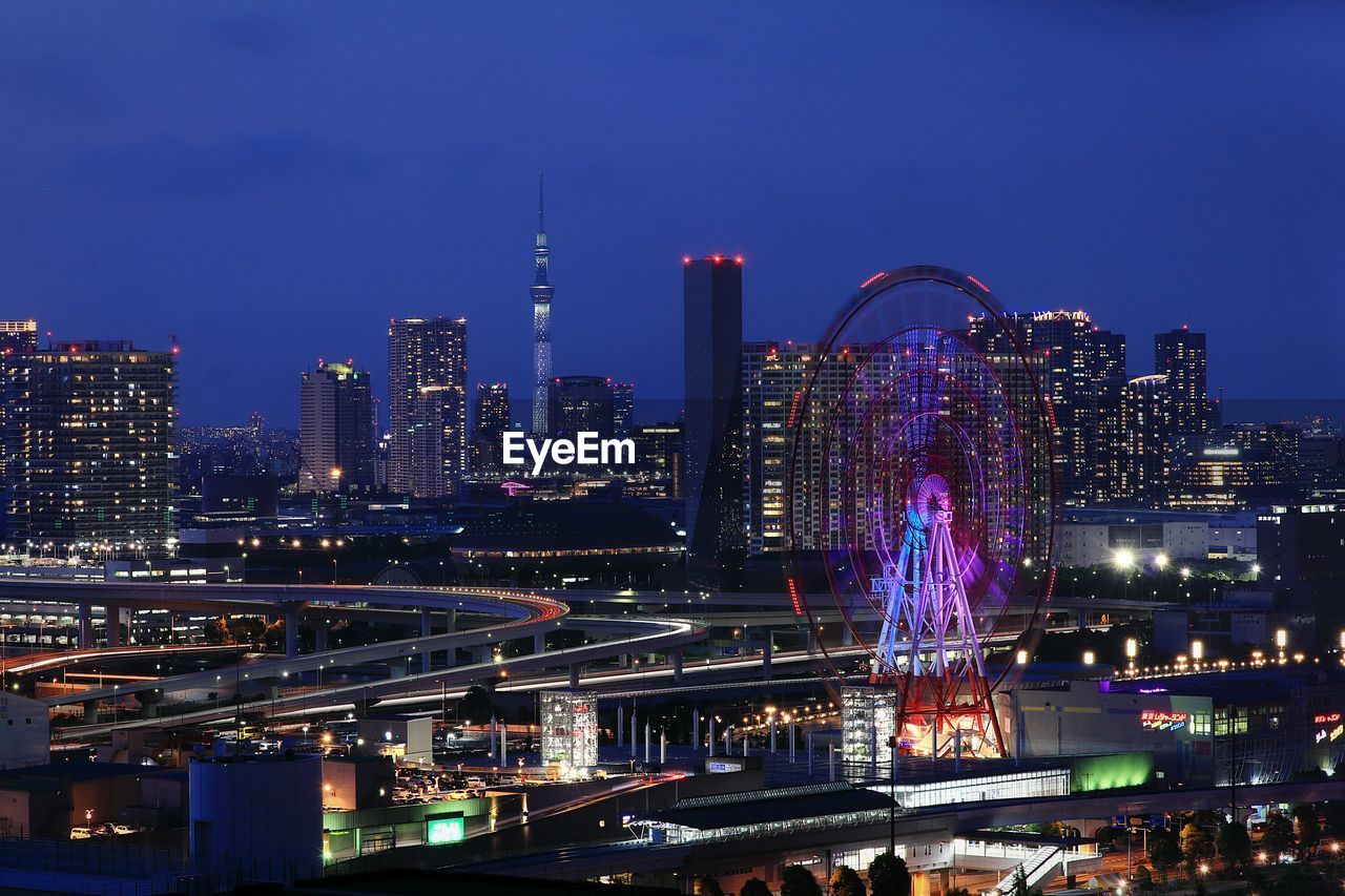 ILLUMINATED CITYSCAPE AGAINST SKY