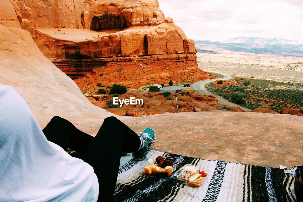 Low section of person sitting at arches national park