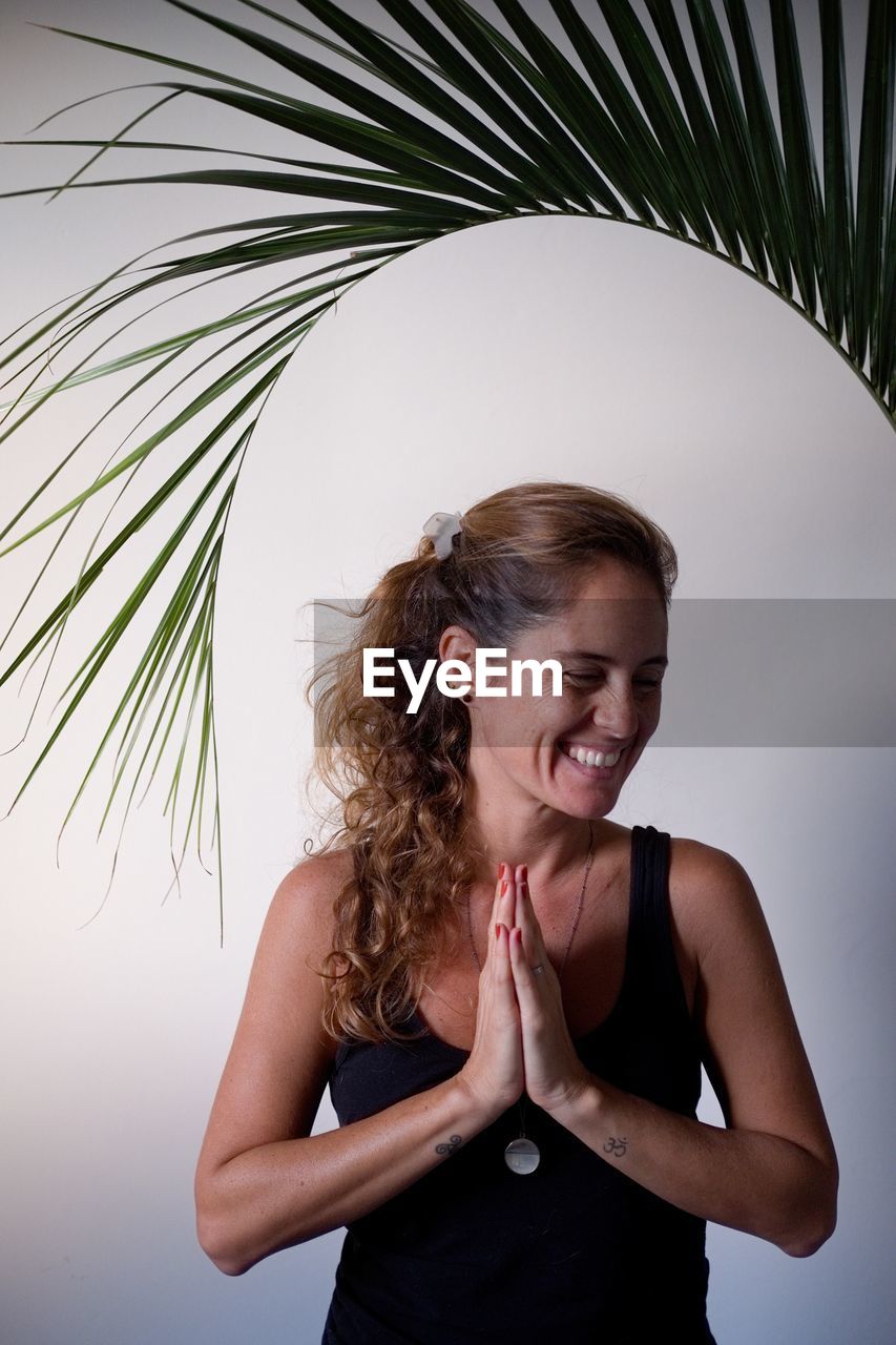 Woman making yoga pose at home with white background