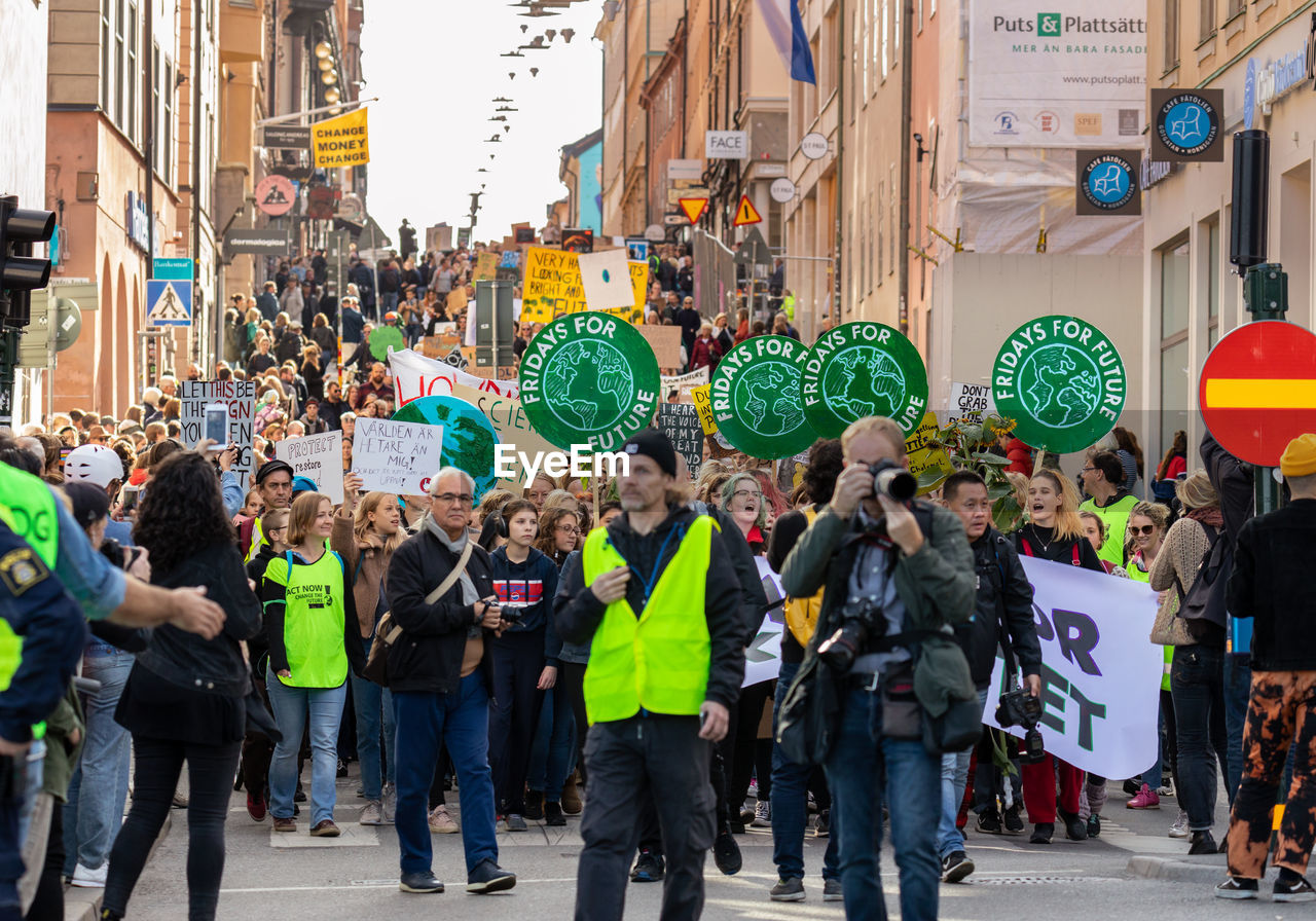 crowd, city, group of people, large group of people, street, real people, architecture, building exterior, city life, women, men, adult, walking, city street, road, built structure, day, standing, lifestyles