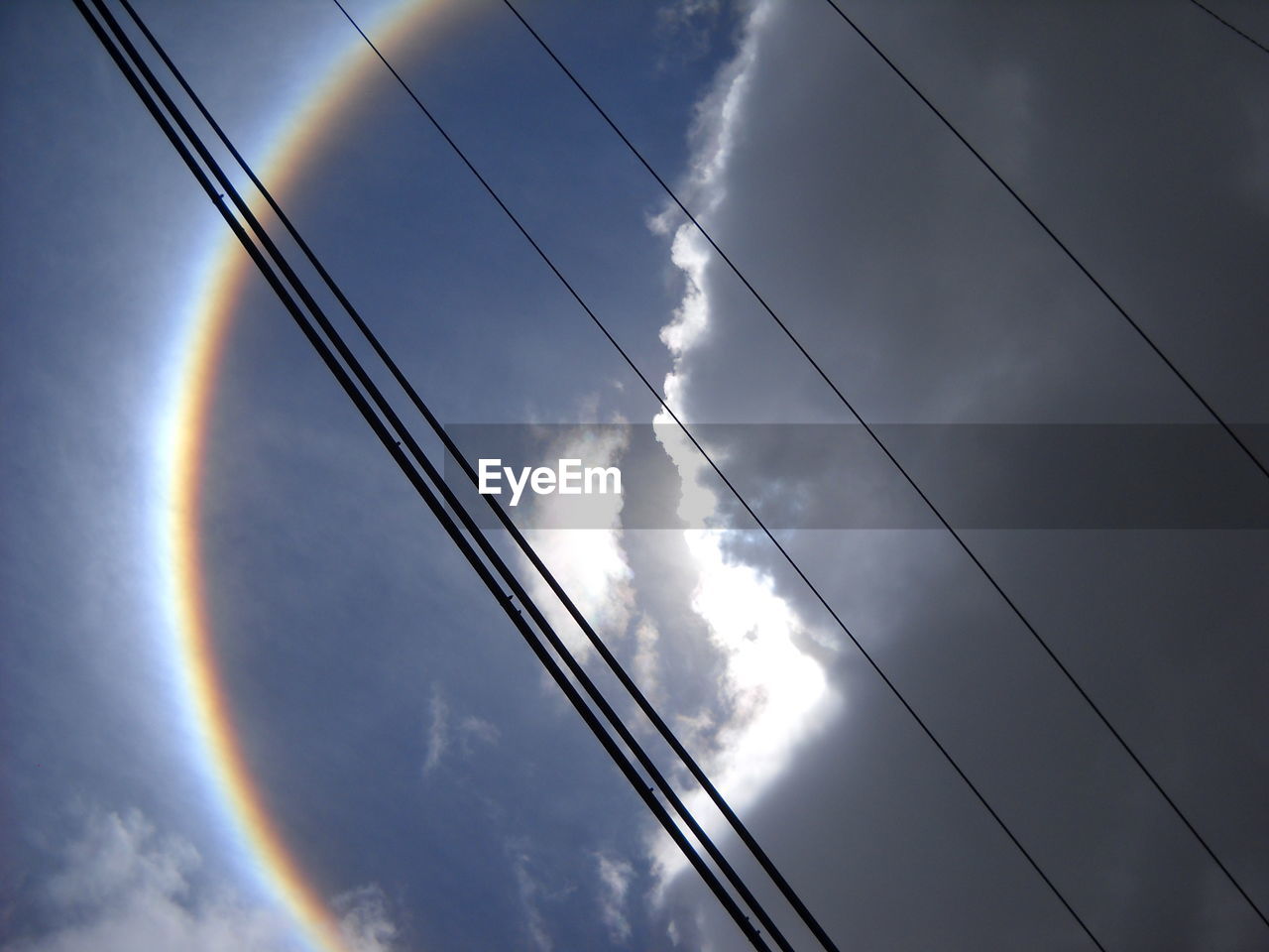 LOW ANGLE VIEW OF POWER LINES AGAINST CLOUDY SKY