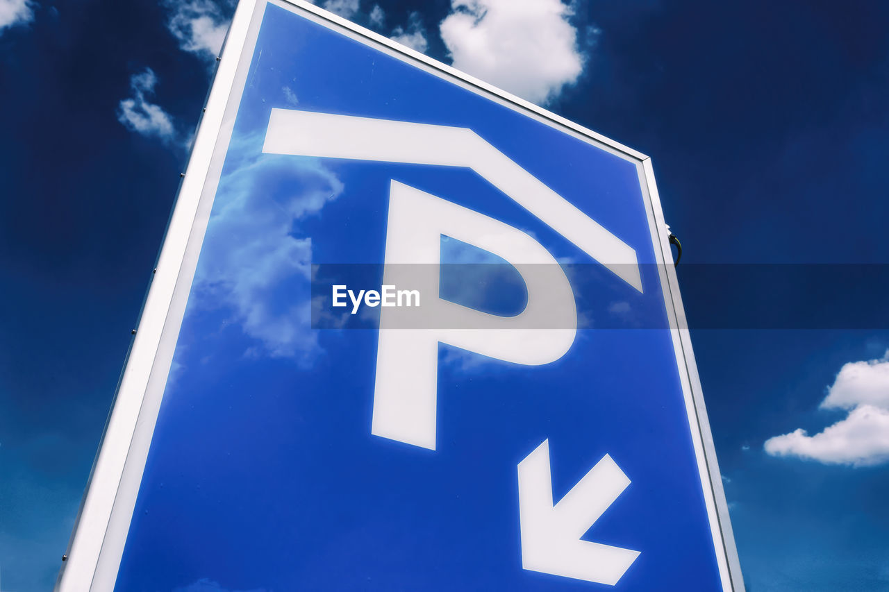 CLOSE-UP OF ROAD SIGN AGAINST BLUE SKY