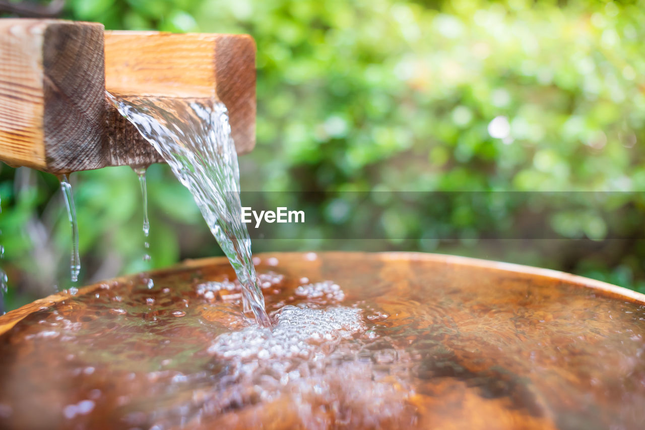 CLOSE-UP OF WATER FALLING FROM GLASS