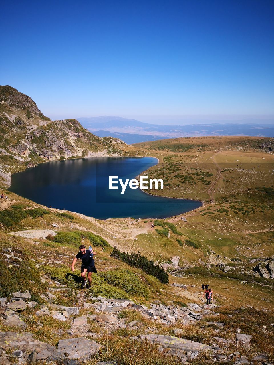 High angle view of man on mountain against blue sky