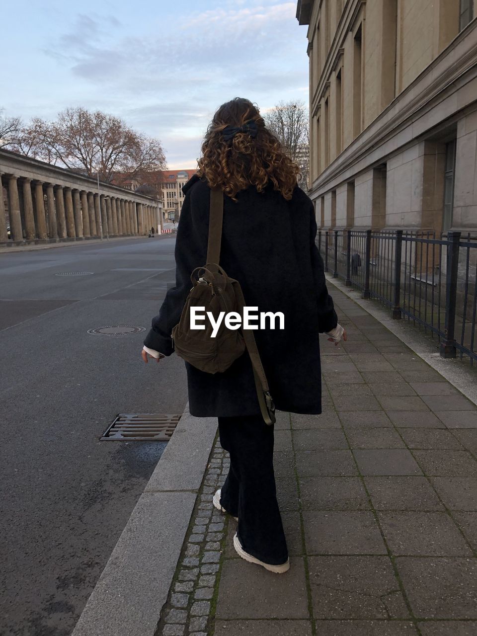 FULL LENGTH REAR VIEW OF WOMAN WALKING ON FOOTPATH