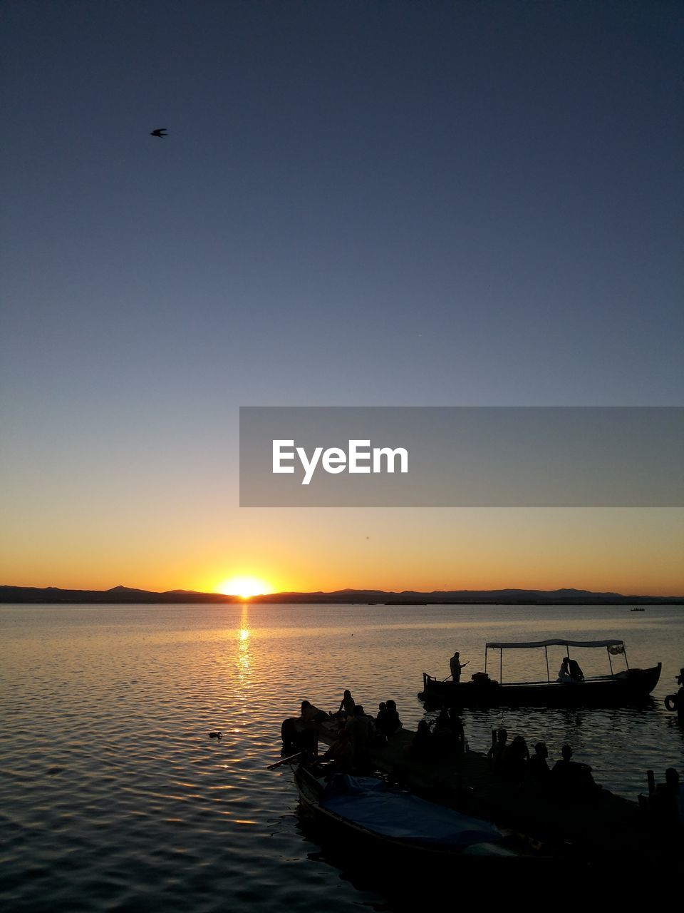 Silhouette of boat in sea at sunset