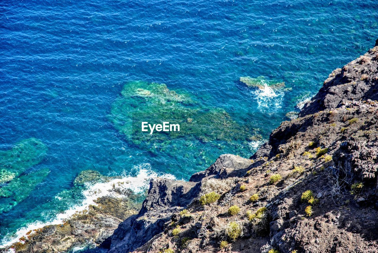 High angle view of rocks by sea