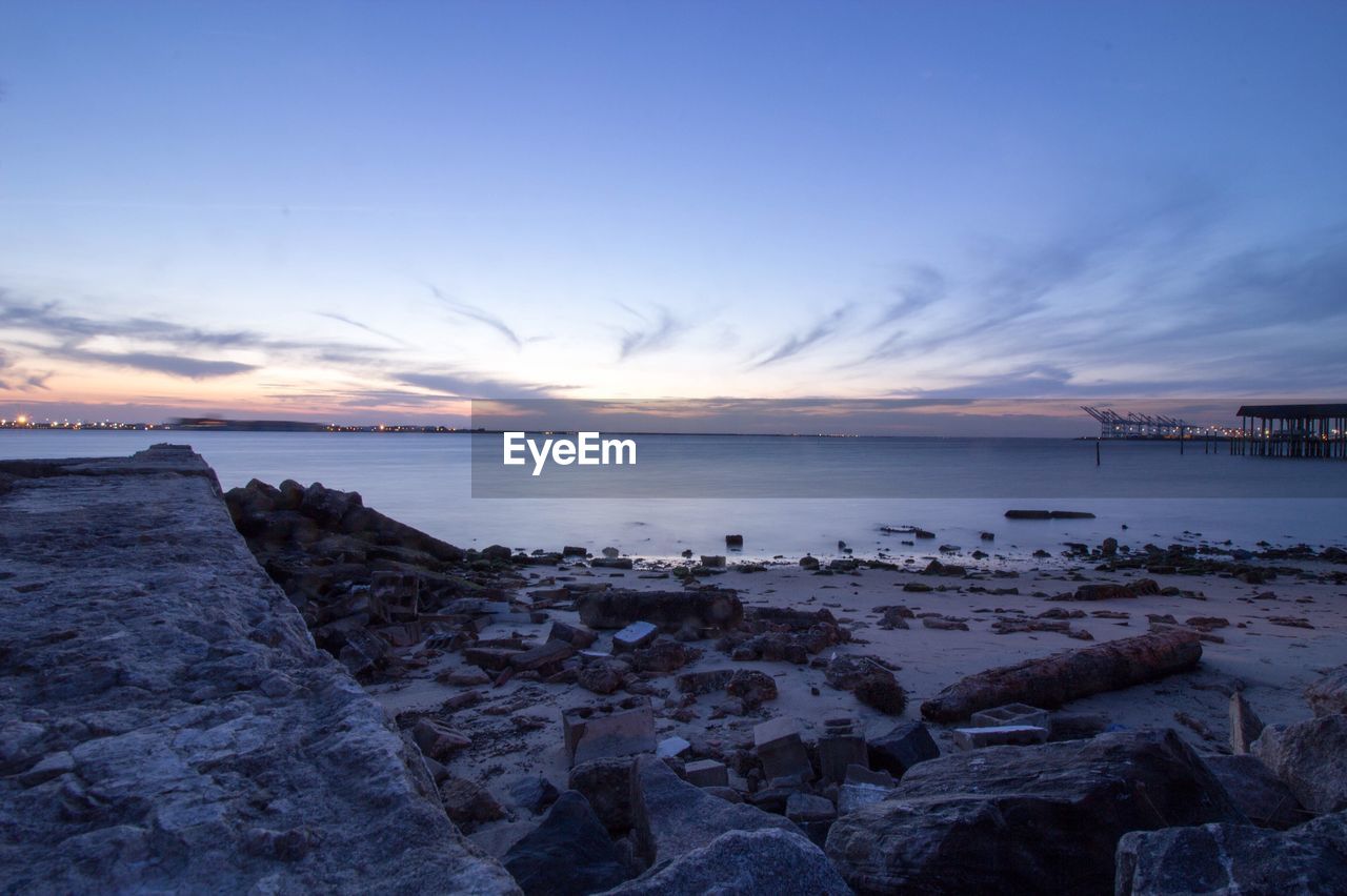 Scenic view of beach against cloudy sky