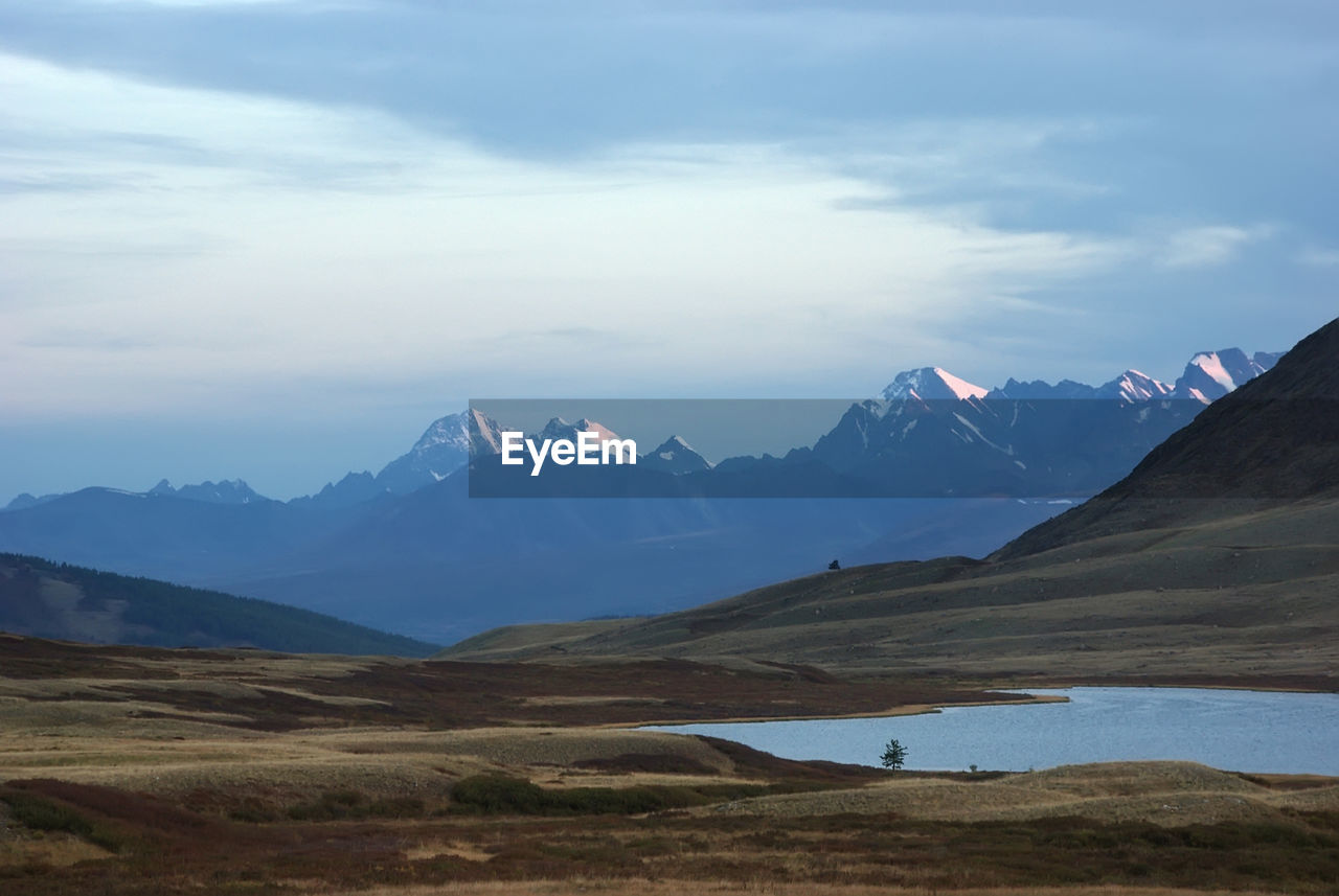 Scenic view of mountains against cloudy sky