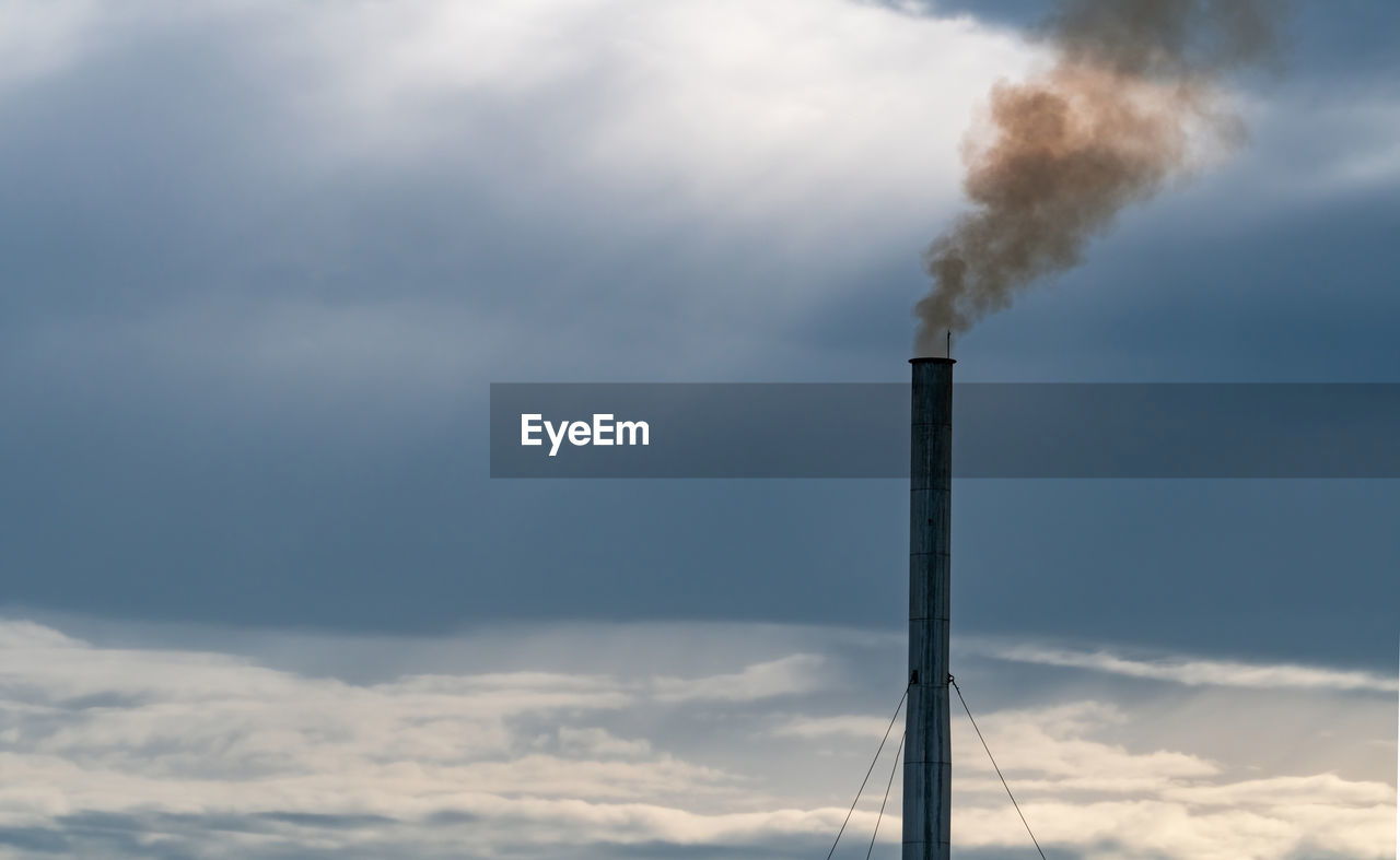 Low angle view of smoke emitting from chimney against sky. air pollution from factory. 