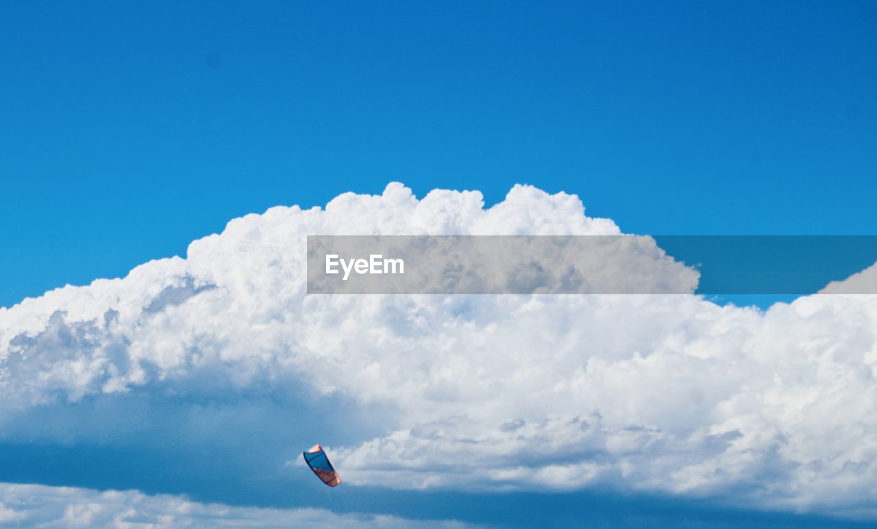 Low angle view of kite flying against blue sky