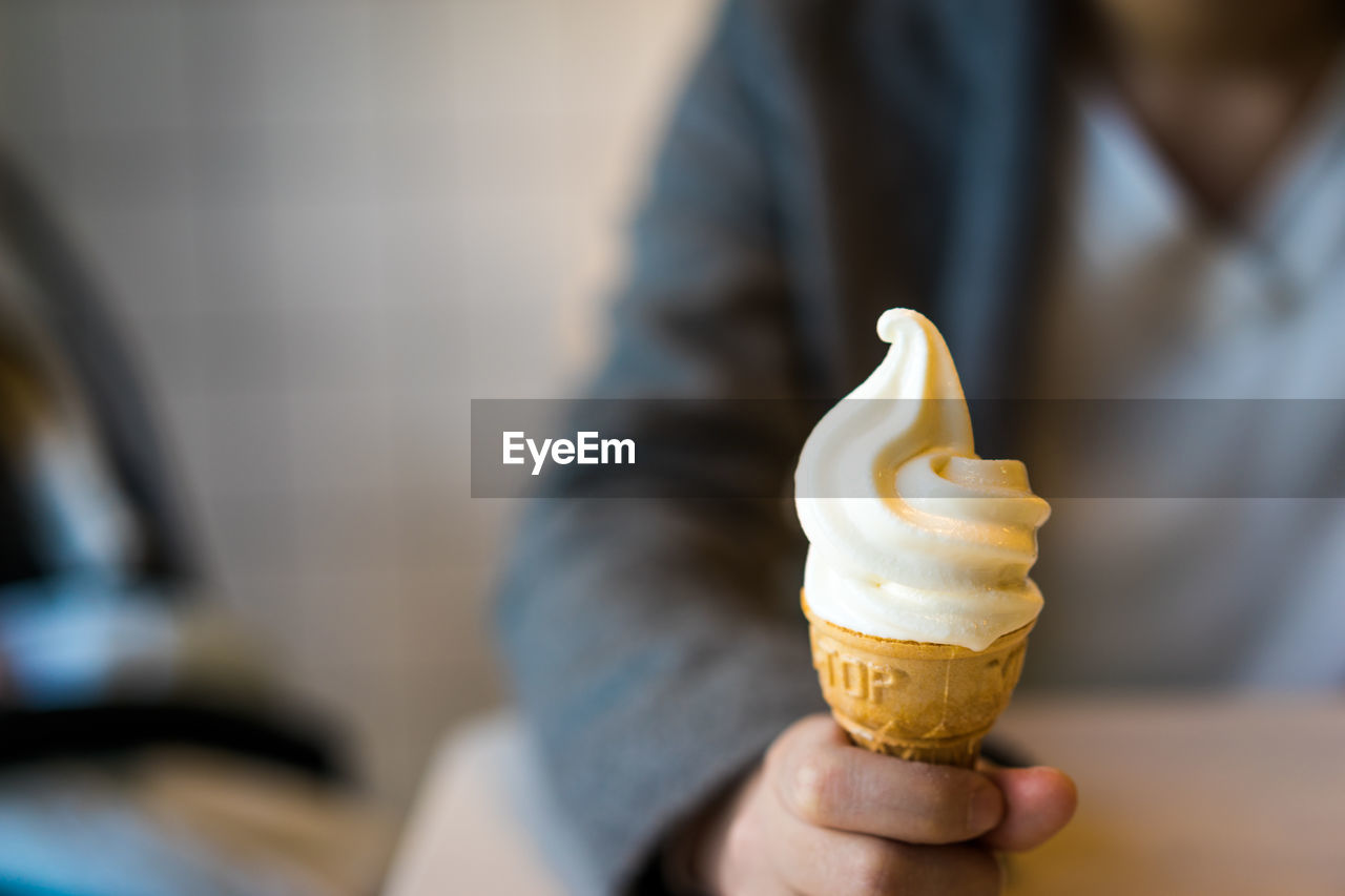 CROPPED IMAGE OF HAND HOLDING ICE CREAM CONE