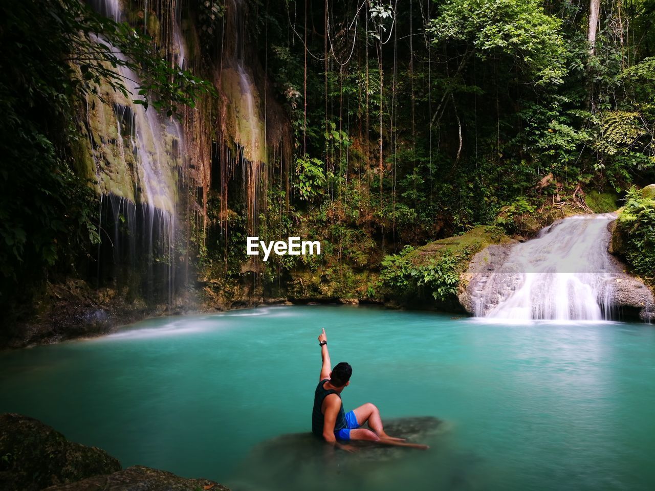 Young man by waterfall