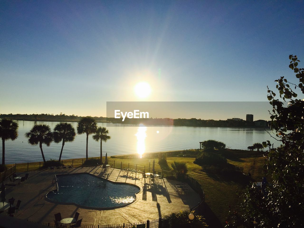 High angle view of swimming pool by lake against bright sky