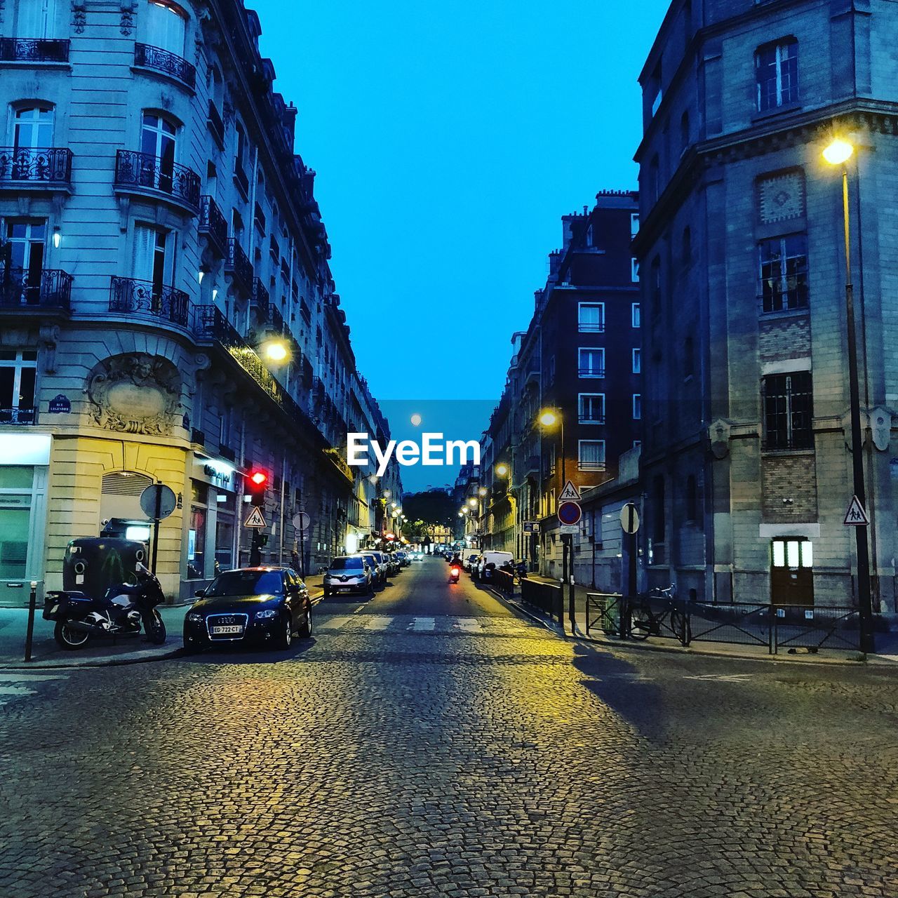 EMPTY ROAD AMIDST BUILDINGS AT NIGHT