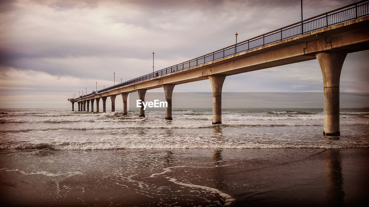 Pier on sea against cloudy sky