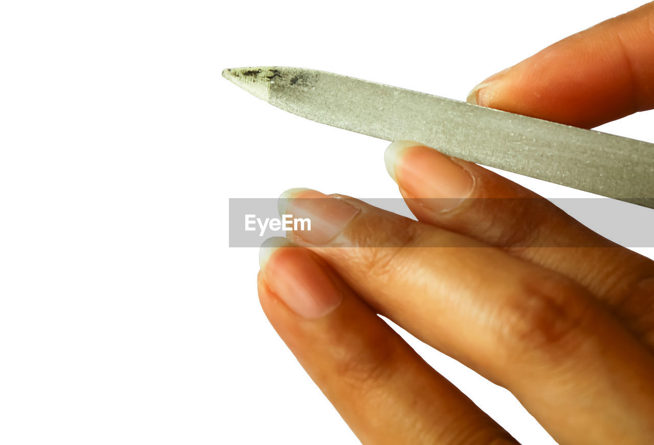 Close-up of woman filing nail over white background