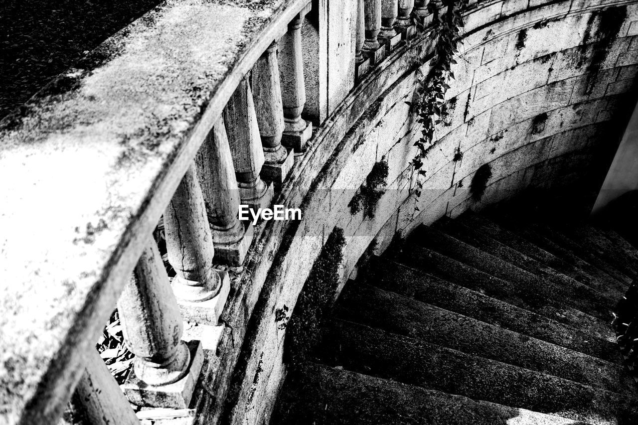 HIGH ANGLE VIEW OF OLD STAIRCASE AMIDST WALL