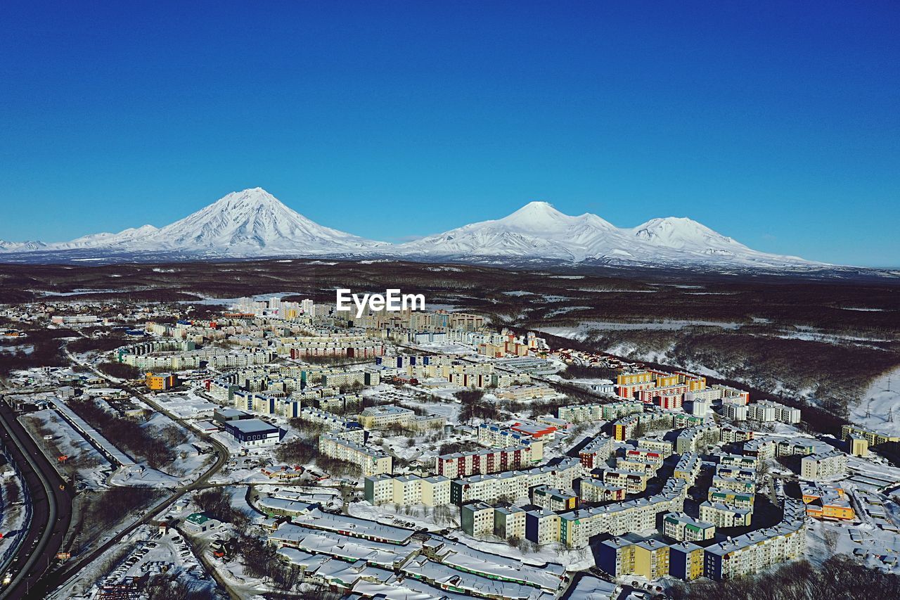 Aerial view of snowcapped mountains against clear blue sky