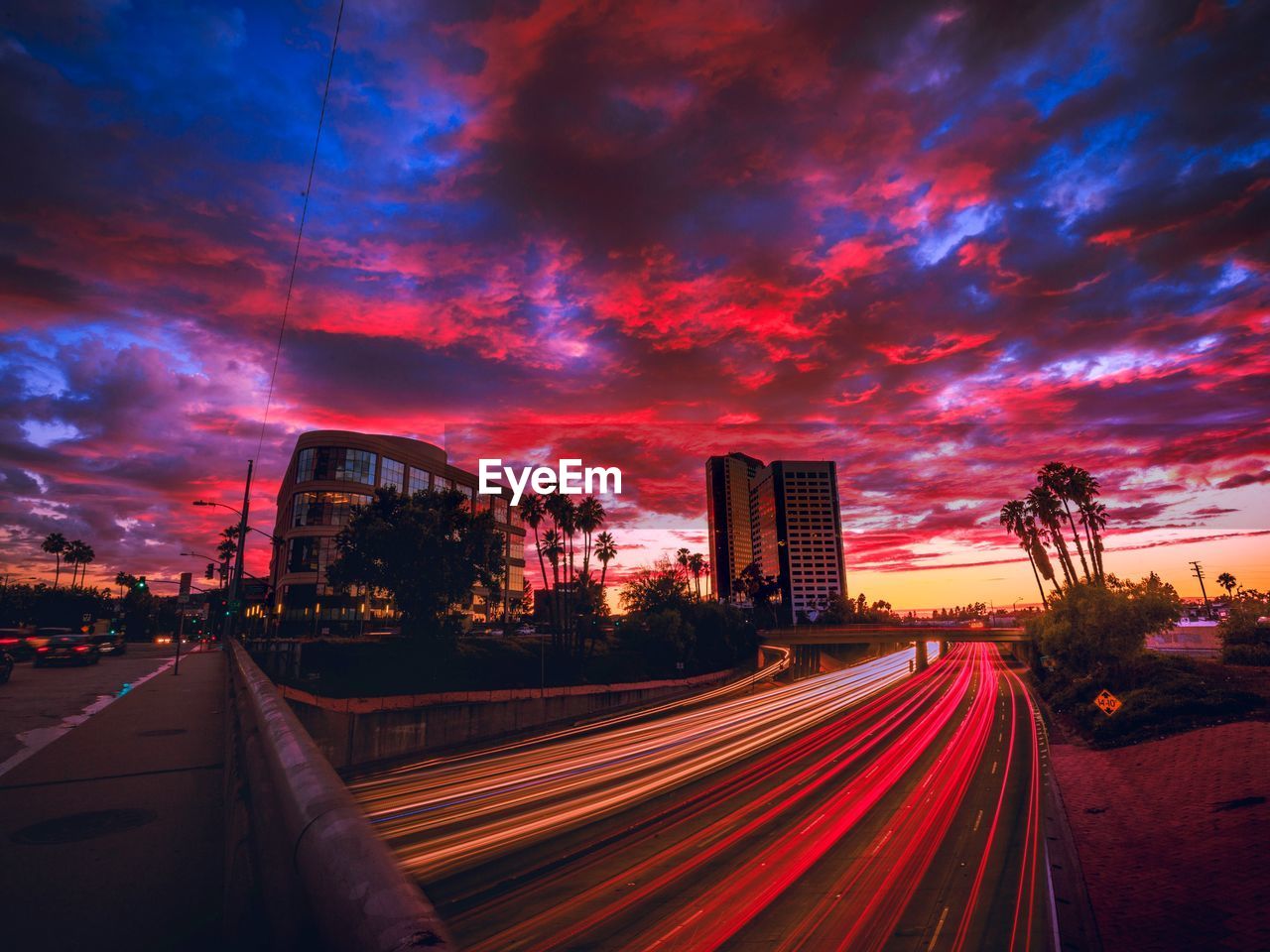 Light trails on road against sky during sunset