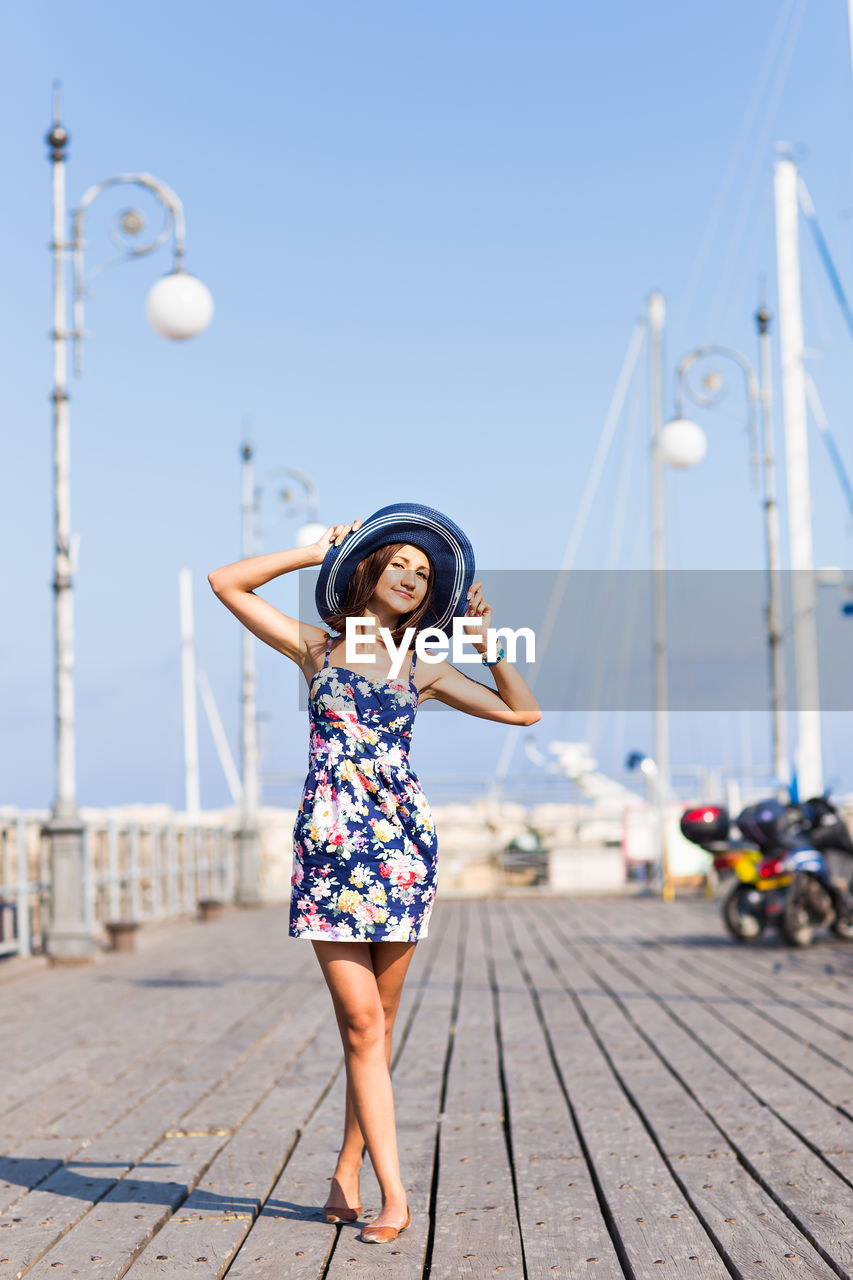 Full length of woman standing on pier against clear sky