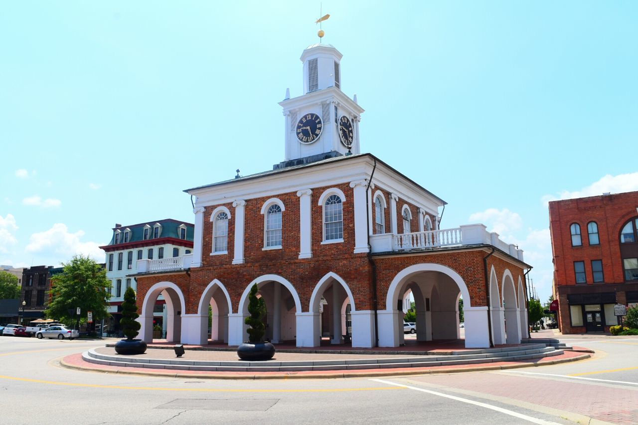 Old market house by street against sky