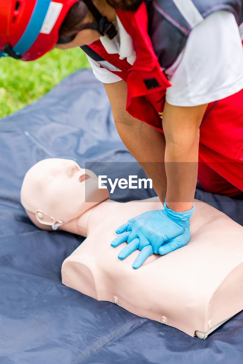 Healthcare worker practicing on cpr dummy at park