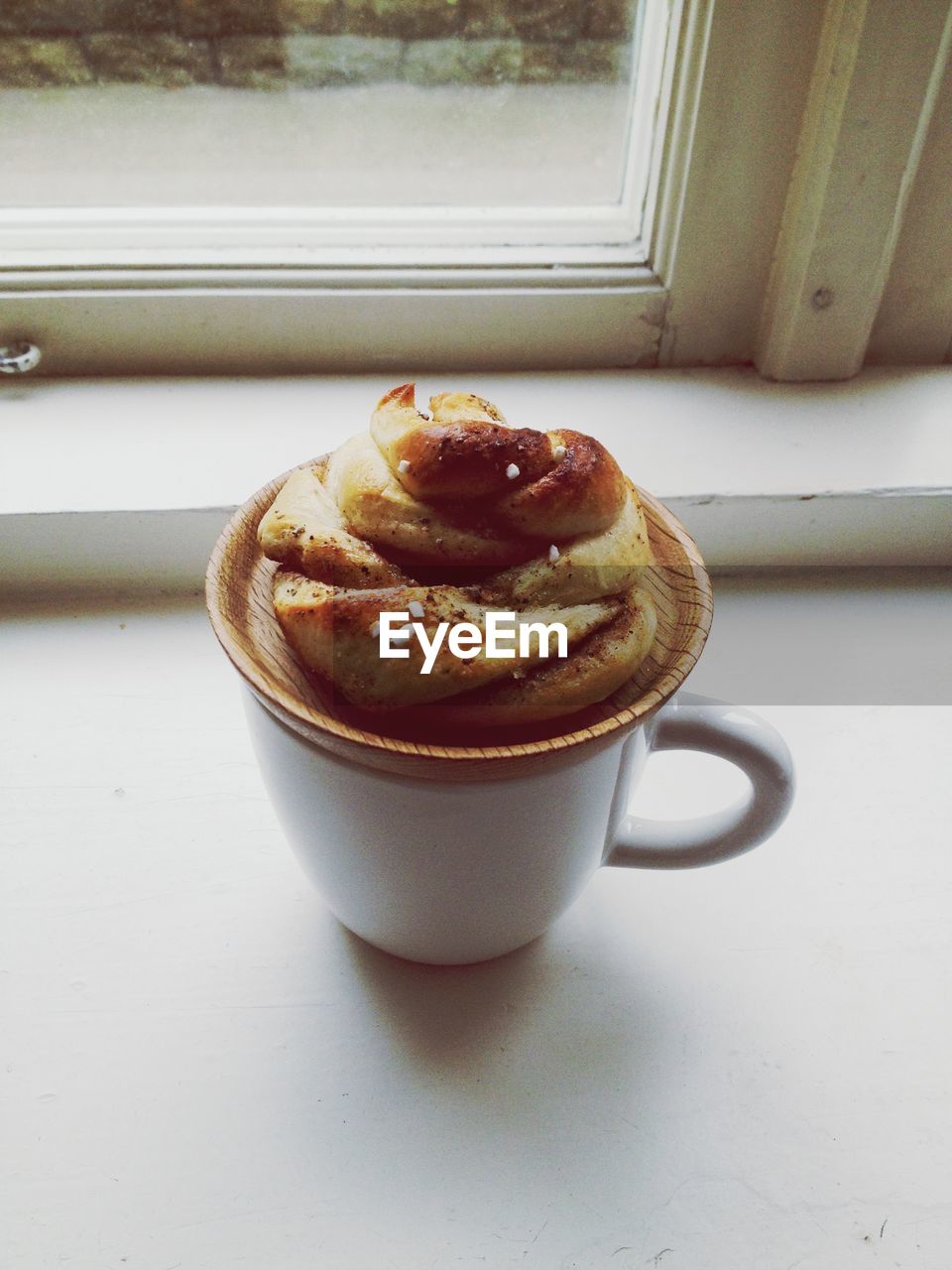 HIGH ANGLE VIEW OF COFFEE WITH CREAM AND SPOON ON TABLE