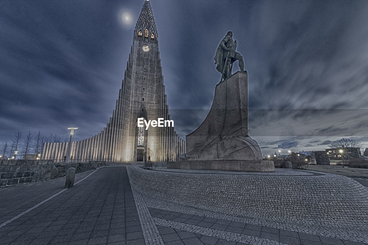 PANORAMIC VIEW OF CITY STREET AND BUILDINGS AGAINST SKY AT NIGHT