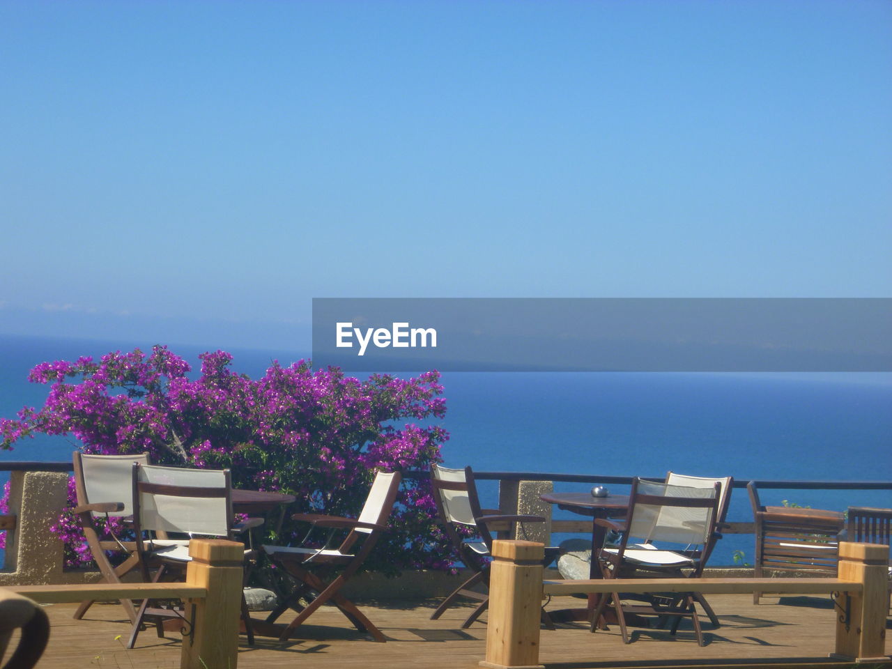 CHAIRS AND TABLE AGAINST BLUE SEA